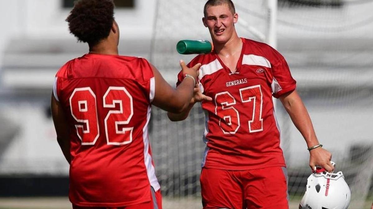 Lafayette offensive lineman, Jedrick Wills tossed a water bottle to Landon Young at practice on Tuesday July 21, 2015 in Lexington, Ky.
