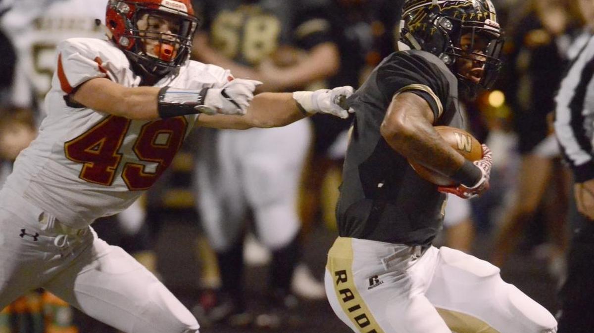 Warren G. Harding quarterback Lynn Bowden rushes down the sideline as Brecksville’s Michael Graham (49) goes for the tackle during action in a high school game this past season. Bowden signed with Kentucky for the 2017 college football season.