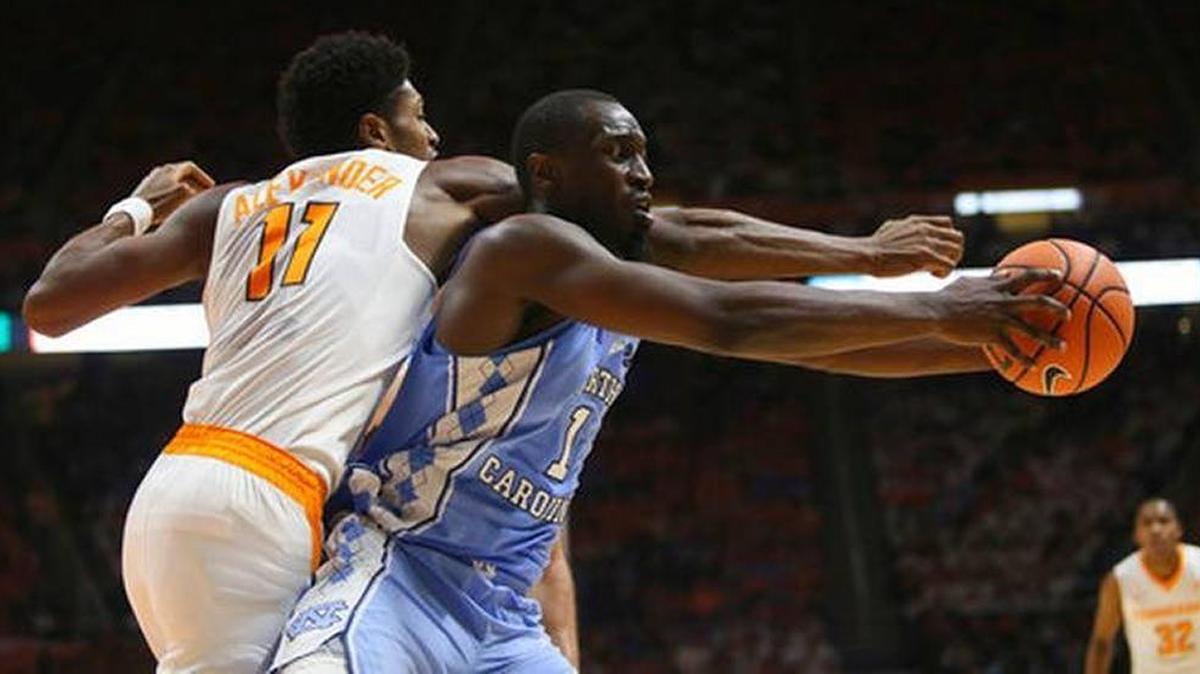 Tennessee center Kyle Alexander goes over the back of North Carolina’s Theo Pinson during North Carolina’s 78-73 victory in a college basketball game in Knoxville, Tenn. on Dec. 17, 2017.