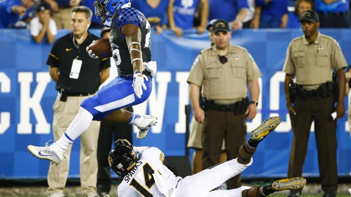 Kentucky running back Benny Snell Jr. (26) leaps over Missouri defensive back Adam Sparks (14) as he runs the ball for a 71-yard touchdown during UK’s 40-34 victory at Kroger Field in Lexington, Ky., Saturday, Oct. 7, 2017.