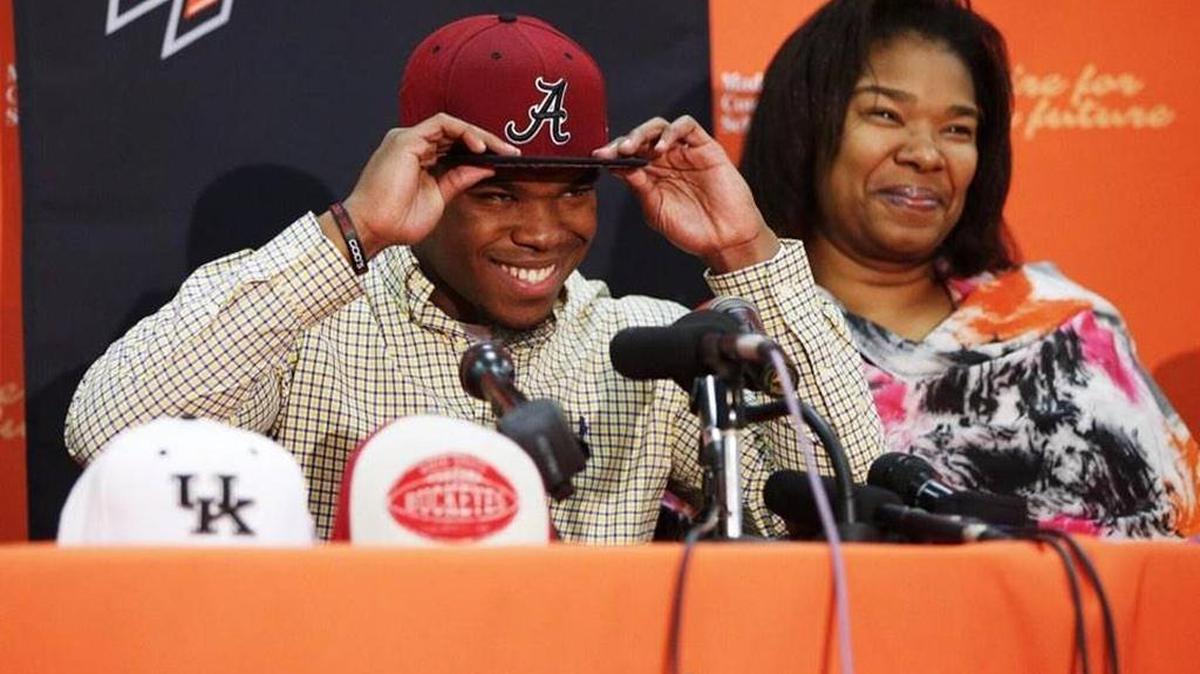 Madison Southern star Damien Harris tries on an Alabama hat after committing to the Crimson Tide on Jan. 9, 2015.