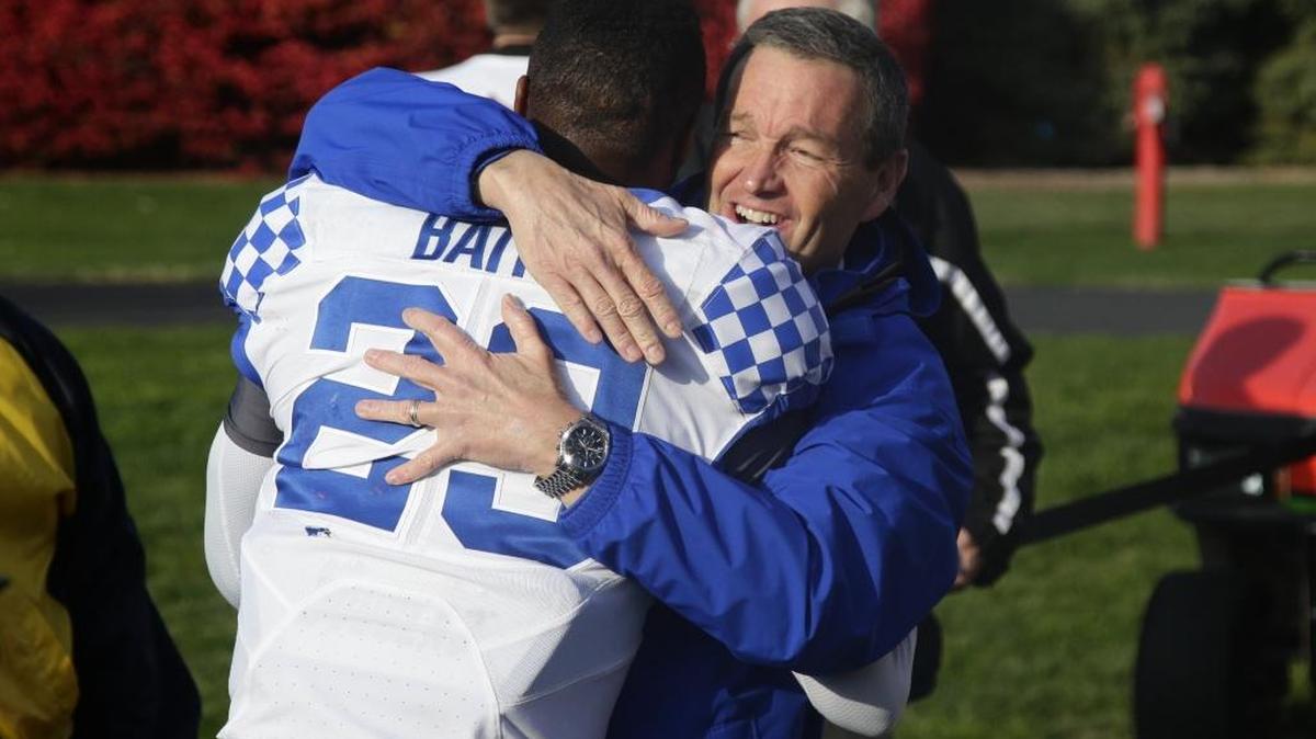Kentucky cornerback Derrick Baity (29) got a big hug from UK athletic director Mitch Barnhart after Kentucky defeated host Louisville 41-38 on Saturday November 26, 2016 in Louisville, Ky.