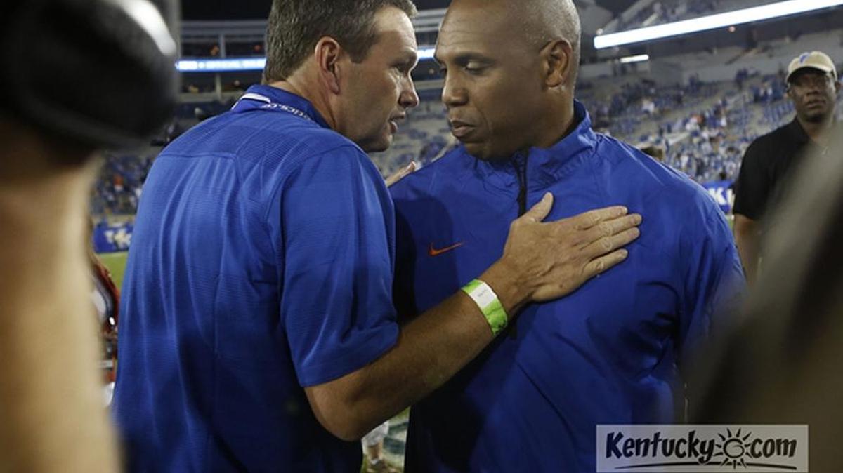 Kentucky athletics director Mitch Barnhart talks with former UK coach Joker Phillips when Phillips was an assistant coach at Florida in 2013.