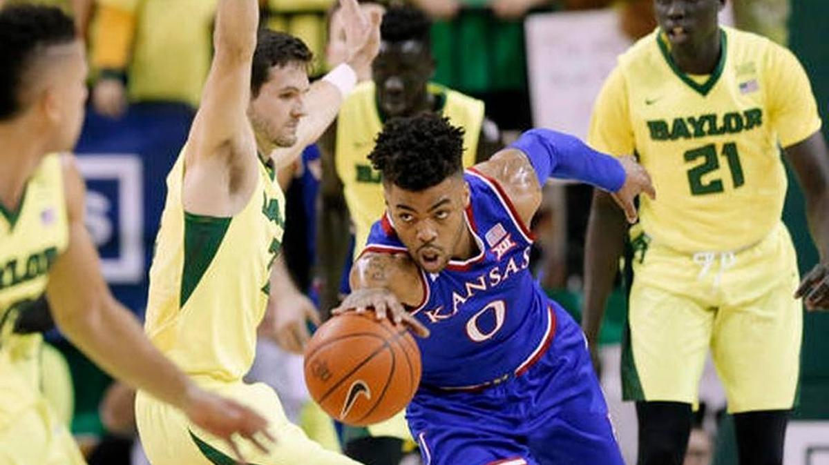 Kansas guard Frank Mason III 0) reaches out to secure a rebound in front of Baylor’s Jake Lindsey, center left, and Nuni Omot during the Jayhawks’ 67-65 win over the Bears in Waco, Texas.