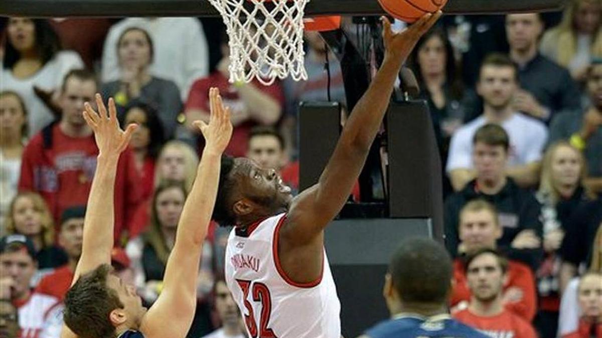 Louisville’s Chinanu Onuaku (32) attempts a layup past the defense of Pittsburgh's Rafael Maia (5) and Chris Jones (12) during the first half of an NCAA college basketball game, Thursday, Jan. 14, 2016, in Louisville, Ky.