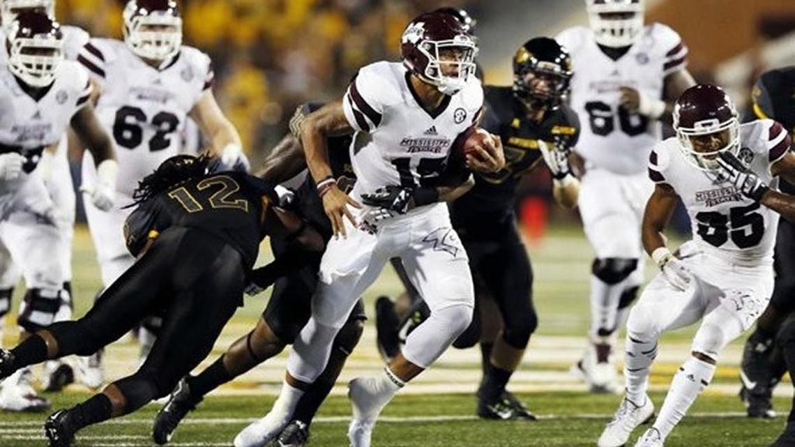Mississippi State quarterback Dak Prescott (15) runs through Southern Mississippi defenders during the second half of MSU’s 34-16 win in Hattiesburg Miss. on Saturday, Sept. 5, 2015.