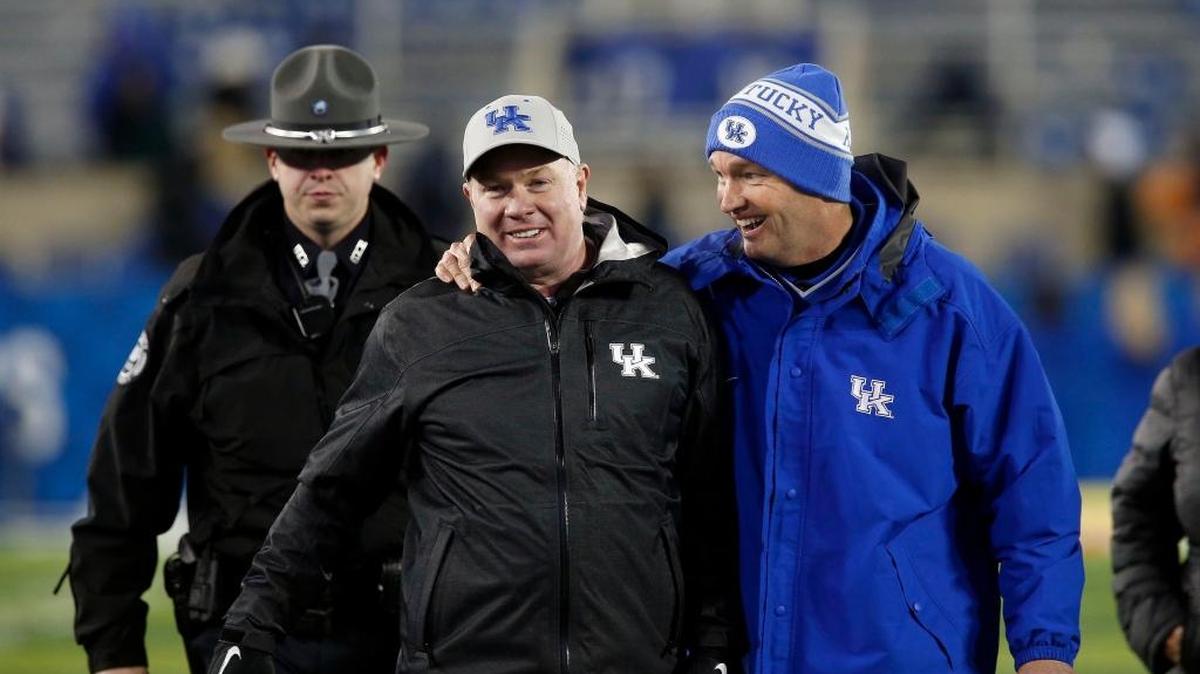 Coach Mark Stoops and UK Athletic Director Mitch Barnhart were all smiles as they walked off the field after the University of Kentucky Wildcats defeated UNC Charlotte 49ers at Commonwealth Stadium in Lexington, Ky., Saturday, November 21, 2015. UK won 58-10.
