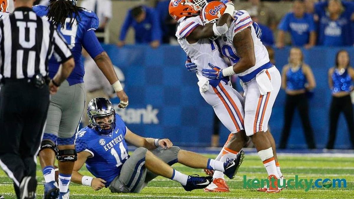 Kentucky quarterback Patrick Towles (14) lay on the ground after taking a fourth quarter sack in UK’s 14-9 loss to Florida last season at Commonwealth Stadium.