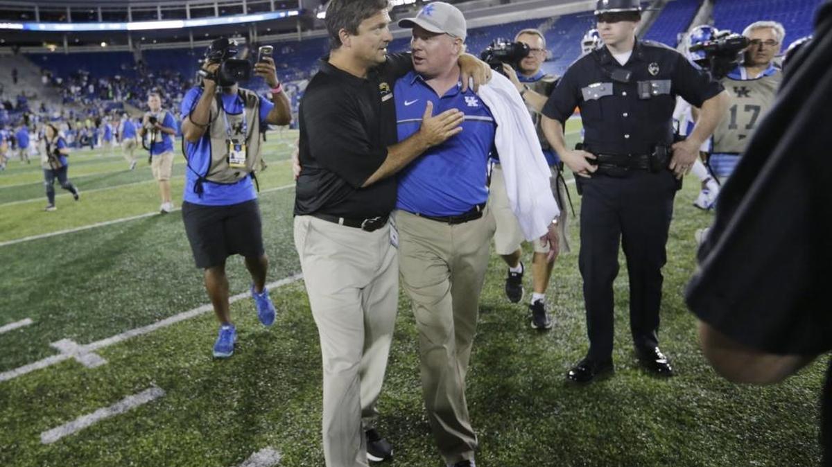 Former offensive coordinator Shannon Dawson, now with Southern Miss, hugged Kentucky head coach Mark Stoops after Southern Mississippi’s 44-35 win over UK on Sept. 3, 2016.