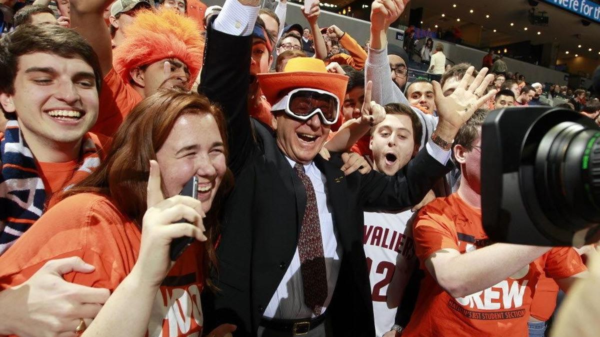 Sportcaster Dick Vitale, center, poses with Virginia fans before an NCAA college basketball game against Louisville, Saturday, Feb. 7, 2015, in Charlottesville, Va.