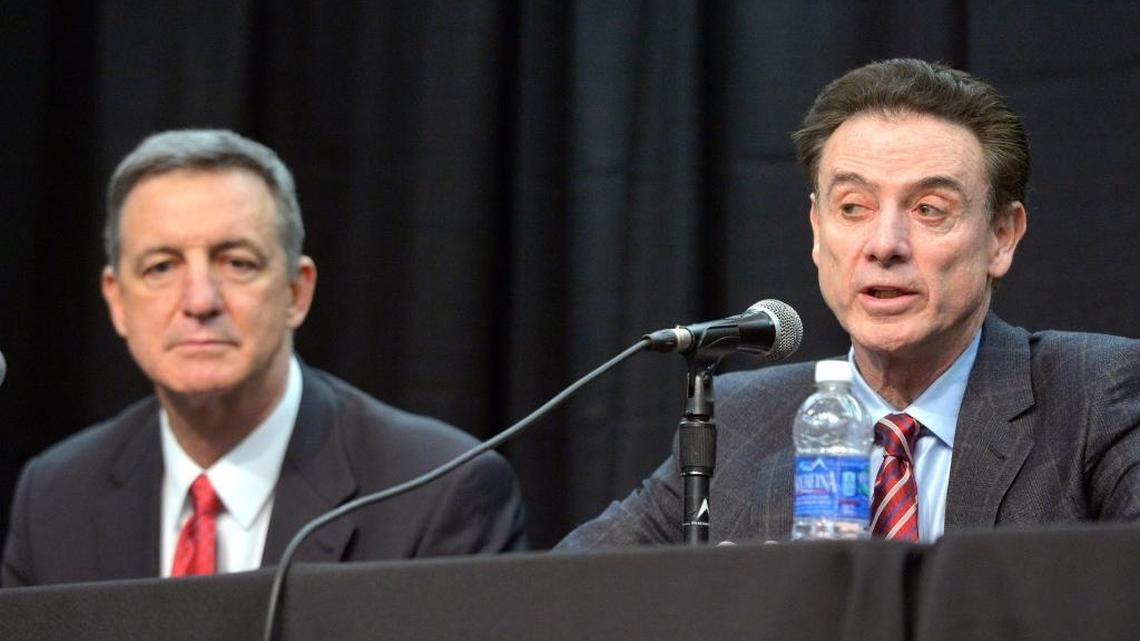Louisville coach Rick Pitino, right, responds to a question as President of the Compliance Group Chuck Smrt listens during a press conference, Friday, Feb. 5, 2016, in Louisville Ky. The University announced a one-year postseason ban for its men's basketball team amid ongoing investigations into a sex scandal in which an escort alleged that a former staffer paid her and other dancers to strip and have sex with recruits and players.