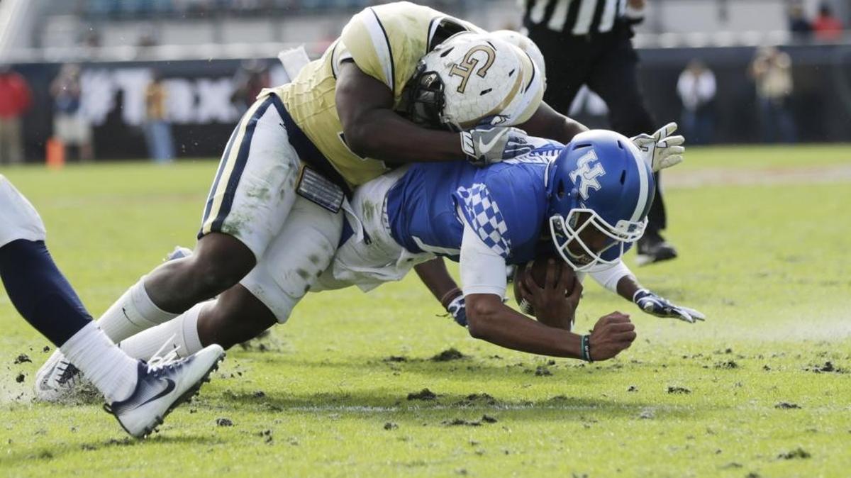 Kentucky quarterback Stephen Johnson was tackled by Georgia Tech linebacker P.J. Davis (40) left and defensive back Lance Austin (17) right as he fell short of a first down in the second half of the Kentucky’s loss in the TaxSlayer Bowl at Everbank Field in Jacksonville, Fla., on Dec. 31, 2016.