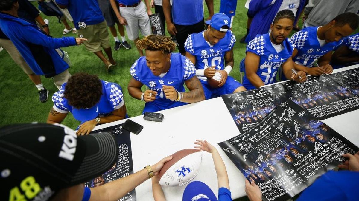Fans gather around running backs Zach Johnson, from left, Benny Snell Jr., A.J. Rose, linebacker Eli Brown and running back Bryant Koback as they sign autographs during Kentucky Football Fan Day at Nutter Field House in Lexington, Ky., Saturday, Aug. 5, 2017.
