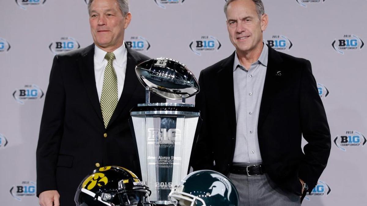 Iowa head coach Kirk Ferentz, left, and Michigan State head coach Mark Dantonio pose with the championship trophy during a news conference for the Big Ten Conference championship NCAA college football game Friday, Dec. 4, 2015, in Indianapolis. Iowa will play Michigan State Saturday for the championship.